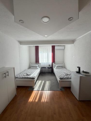 een kamer met drie bedden en een raam bij Sobe kod bolnice Paprikovac in Banja Luka