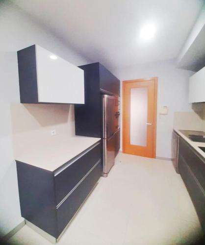 a kitchen with black and white counters and a refrigerator at Private Garden and Pool in the Heart of Funchal in Funchal