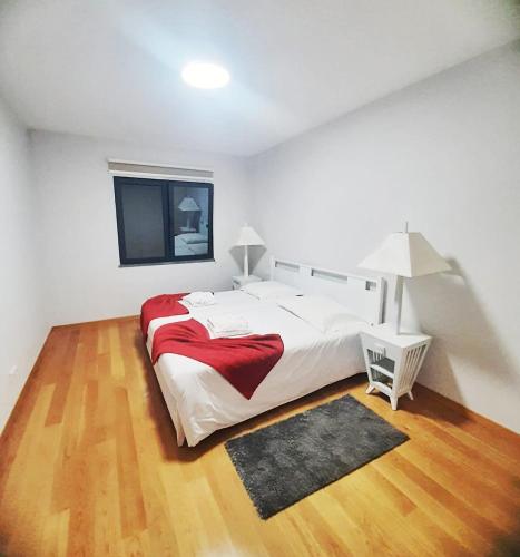 a large white bedroom with a large bed and a rug at Private Garden and Pool in the Heart of Funchal in Funchal