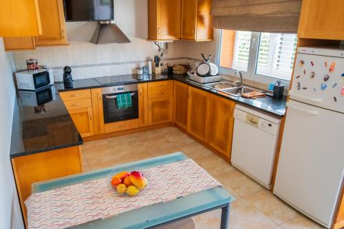 a kitchen with a table with a bowl of fruit on it at Verde Verdilhão Villa