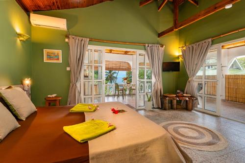 1 dormitorio con 1 cama grande y paredes verdes en Beau Bamboo, en Mahe