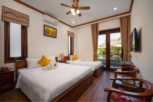 a bedroom with two beds and a ceiling fan at Villa Ban Hien in Hiếu Nhơn