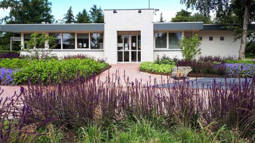 una casa blanca con un jardín delante en Resort Veldhoven, en Veldhoven