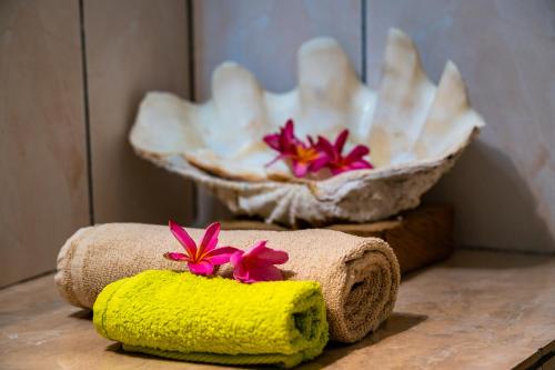 dos toallas con flores en una mesa en Beau Bamboo, en Mahe