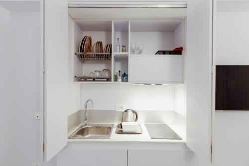 a kitchen with white cabinets and a sink at Atri Rooms Centro Storico Napoli in Naples
