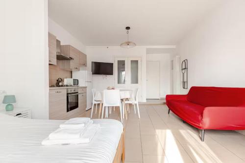 un soggiorno con un divano rosso e una cucina di Casa Angela Apartments a Bergamo