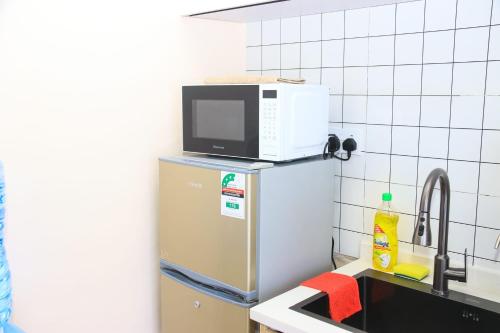 een magnetron bovenop een koelkast in een keuken bij Ww Homes in Nairobi