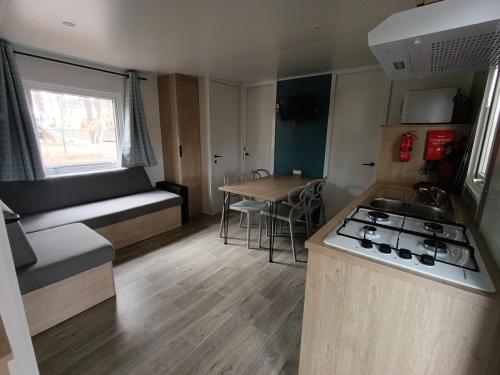 a small kitchen and living room of a caravan at Mobil-home neuf sous les pins, à proximité des infrastructures in Saint-Julien-en-Born