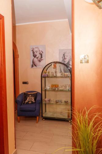 a hallway with a blue chair and a glass case at B&B VILLA BELLA in Catanzaro