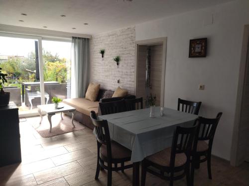 een woonkamer met een tafel en een bank bij Къща за гости ИЛТА in Novo Delchevo