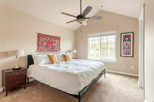 Un dormitorio con una cama y un ventilador de techo. en Family friendly 3 story townhouse with workspace, en Beaverton