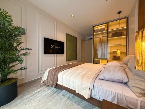 - une chambre avec un grand lit et une télévision murale dans l'établissement Qoople Legend C9 - Luxury apartment in Alanya, à Alanya