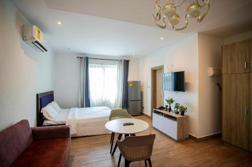 a hotel room with a bed and a table at Legacy Square by QUAO REALTY in East Legon