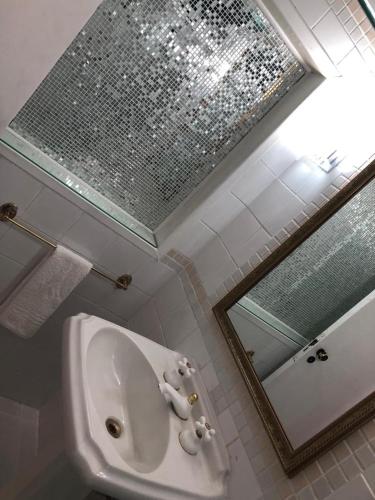 a bathroom with a sink and a mirror at Pousada Quintal das Hortênsias in Salesópolis