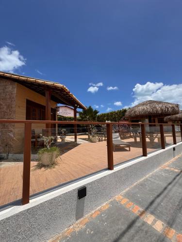 a fence in front of a building with a patio at Pousada Rio Aratuá in Galinhos