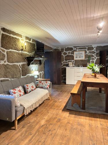 ein Wohnzimmer mit Sofa und Tisch in der Unterkunft Casa do Arte - Peaceful Retreat with a Pool near Guimarães in São Torcato