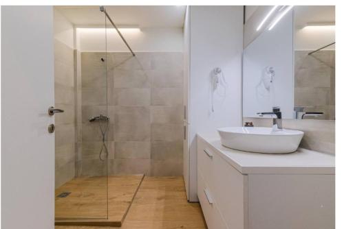 a bathroom with a sink and a glass shower at Ladadika Vibes Apartments 2 in Thessaloniki