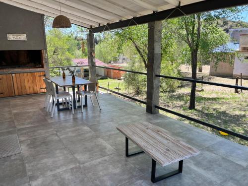 een patio met een tafel en stoelen en een bank bij La Casa del Gringo in Villa Icho Cruz