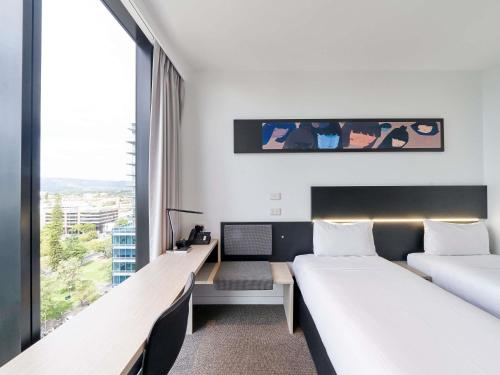 a hotel room with two beds and a window at ibis Adelaide in Adelaide