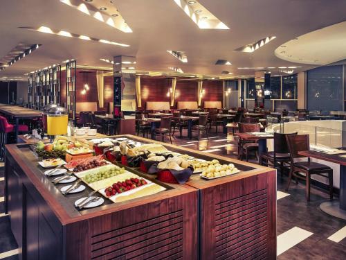 a buffet line with food on it in a restaurant at Mercure Santiago Centro in Santiago