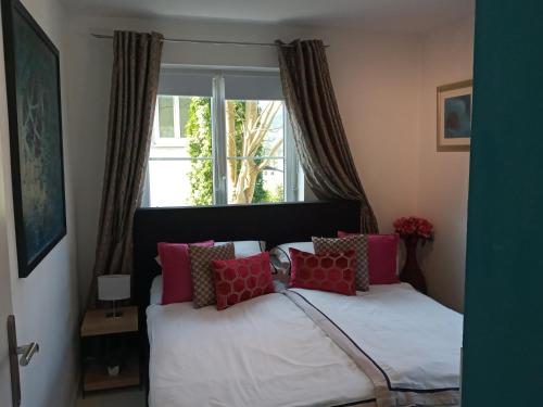 圣沃尔夫冈Schafberg Apartment的卧室里有一张床，上面有红色和白色的枕头