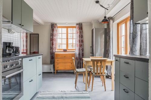 a kitchen with a table and a dining room at Franshammars vandrarhem in Hassela