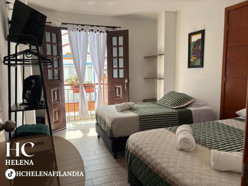 een hotelkamer met twee bedden en een balkon bij HC Helena in Filandia