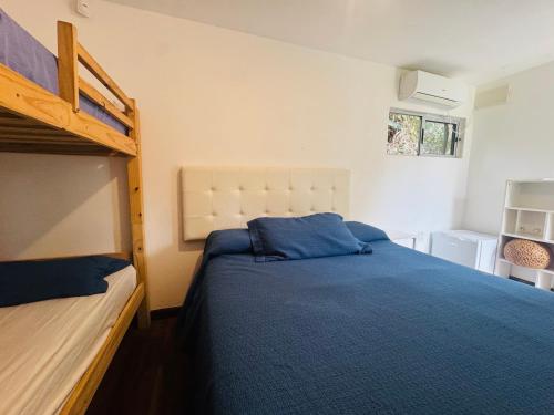 een slaapkamer met een bed en een stapelbed bij Posada Punta del Este in Punta del Este