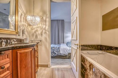 a bathroom with a sink and a tub and a bedroom at Micheal Angelo towers in Johannesburg