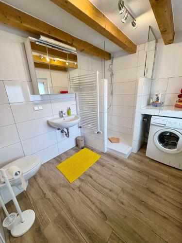 a bathroom with a sink toilet and a washing machine at Ferienhaus Lisbeth in Edesheim
