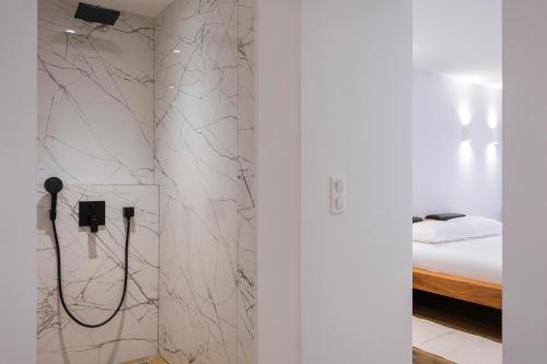 a bathroom with a shower with a white wall at Suite Île du Levant - Jardin & Piscine - 4 pers in La Croix-Valmer