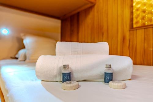 a bed with towels and two bottles on it at Luxury 4BR Apartment with Fireplace & Private Parking - Val Thorens in Val Thorens