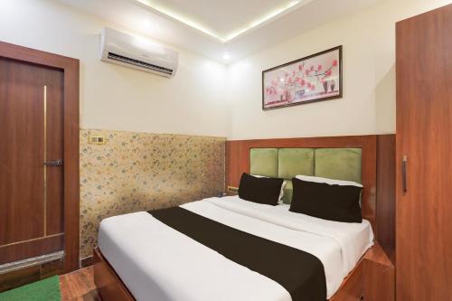 a bedroom with a large bed in a room at Super Townhouse Kali Ghat Prayagraj Formerly Ramesh Palace in Prayagraj