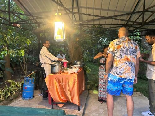 a group of people standing around a table in a tent at Thomasz Lodge 2 in Kandy