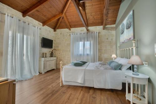 a bedroom with a white bed and a wooden ceiling at Petra Luxury Villa in Heraklio Town