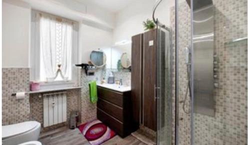 Un baño con ducha, lavabo e inodoro. en oparavisegenova, en Génova