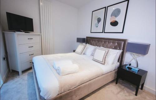a bedroom with a bed and a dresser with a television at 1 Bedroom apartment near Canning Town in London