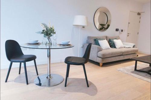 a living room with a table and chairs and a couch at 1 Bedroom apartment near Canning Town in London