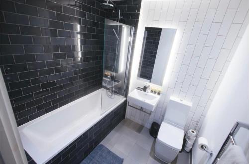 a bathroom with a bath tub and a sink at 1 Bedroom apartment near Canning Town in London