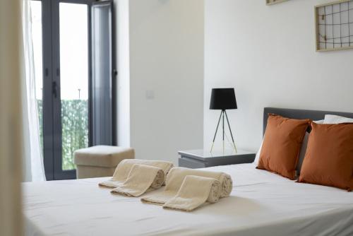 une chambre avec un lit blanc avec des serviettes dessus dans l'établissement Marggisa - City Center by HD, à Faro