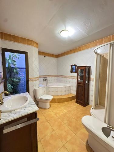 een badkamer met een bad, een toilet en een wastafel bij Great House Almería in Almería