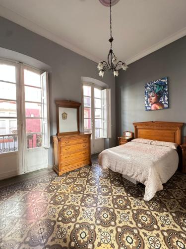 een slaapkamer met een bed, een dressoir en ramen bij Great House Almería in Almería