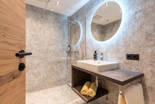 a bathroom with a sink and a mirror at Hotel Grissemann in Flirsch