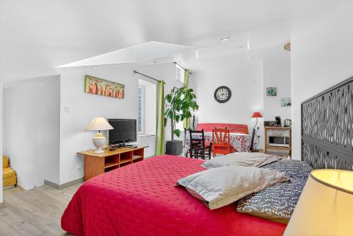 a bedroom with a bed and a desk and a television at Gîte Mélano - La Grange du Logis in Villevieille
