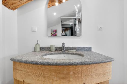 a bathroom with a sink in a wooden barrel at Gîte Mélano - La Grange du Logis in Villevieille