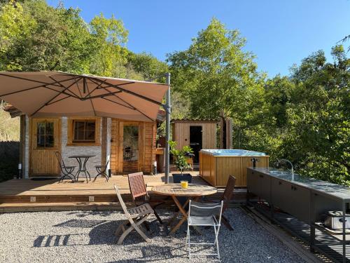 a patio with an umbrella and a table and chairs at Chalet d hiver in Millau
