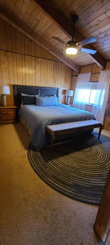a bedroom with a large bed on a rug at Lakeview Lodge, bookable boat slip! in Bass Lake