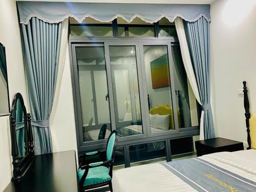 a bedroom with a window with a desk and a bed at Tam Coc Armany Hotel & Sky Restaurant in Vũ Lâm