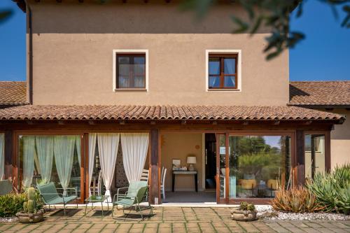 a house with a patio with chairs in front of it at Inghirios Wellness Country Resort in Santa Maria la Palma