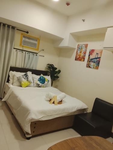 une chambre avec un lit orné d'une croix dans l'établissement The Viceroy Tower Staycation at McKinley Hills Taguig, à Manille